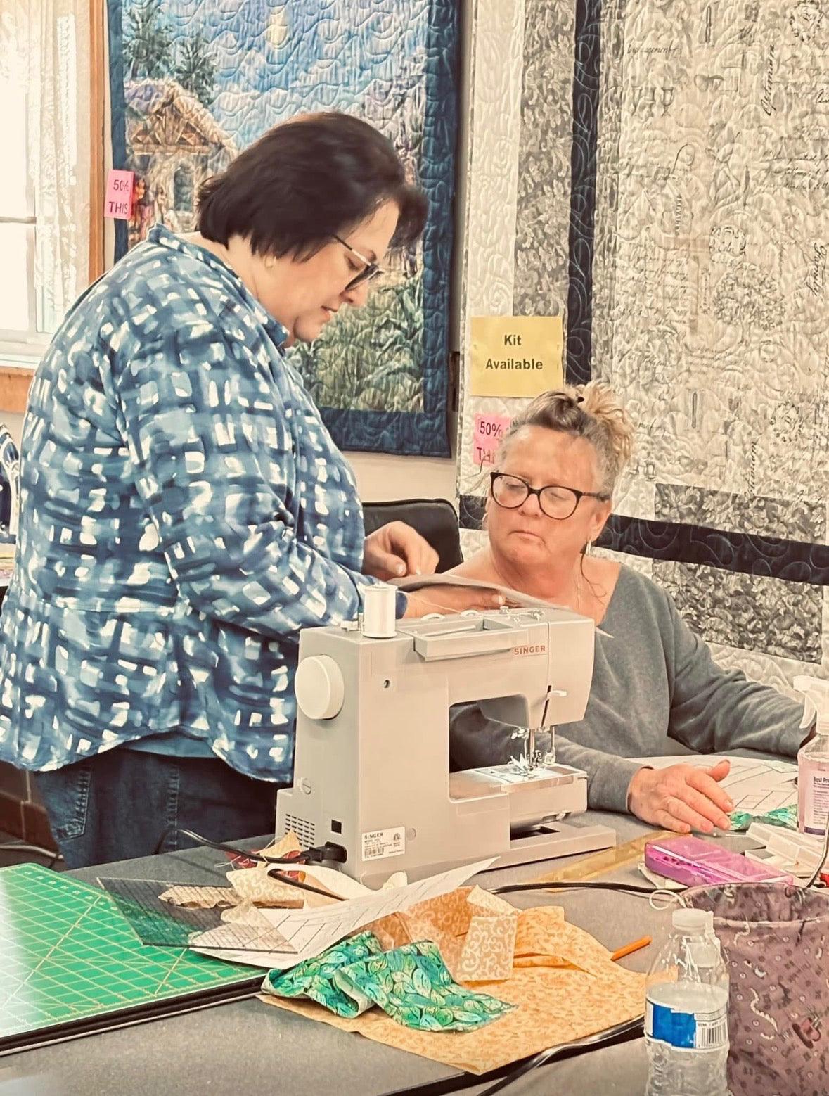 An instructor helping a student at a sewing machine in The Quilting Corner
